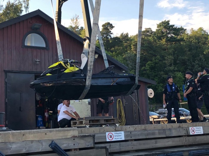 Vattenskoter hissas upp ur vattnet, polis och kustbevakare tittar på
