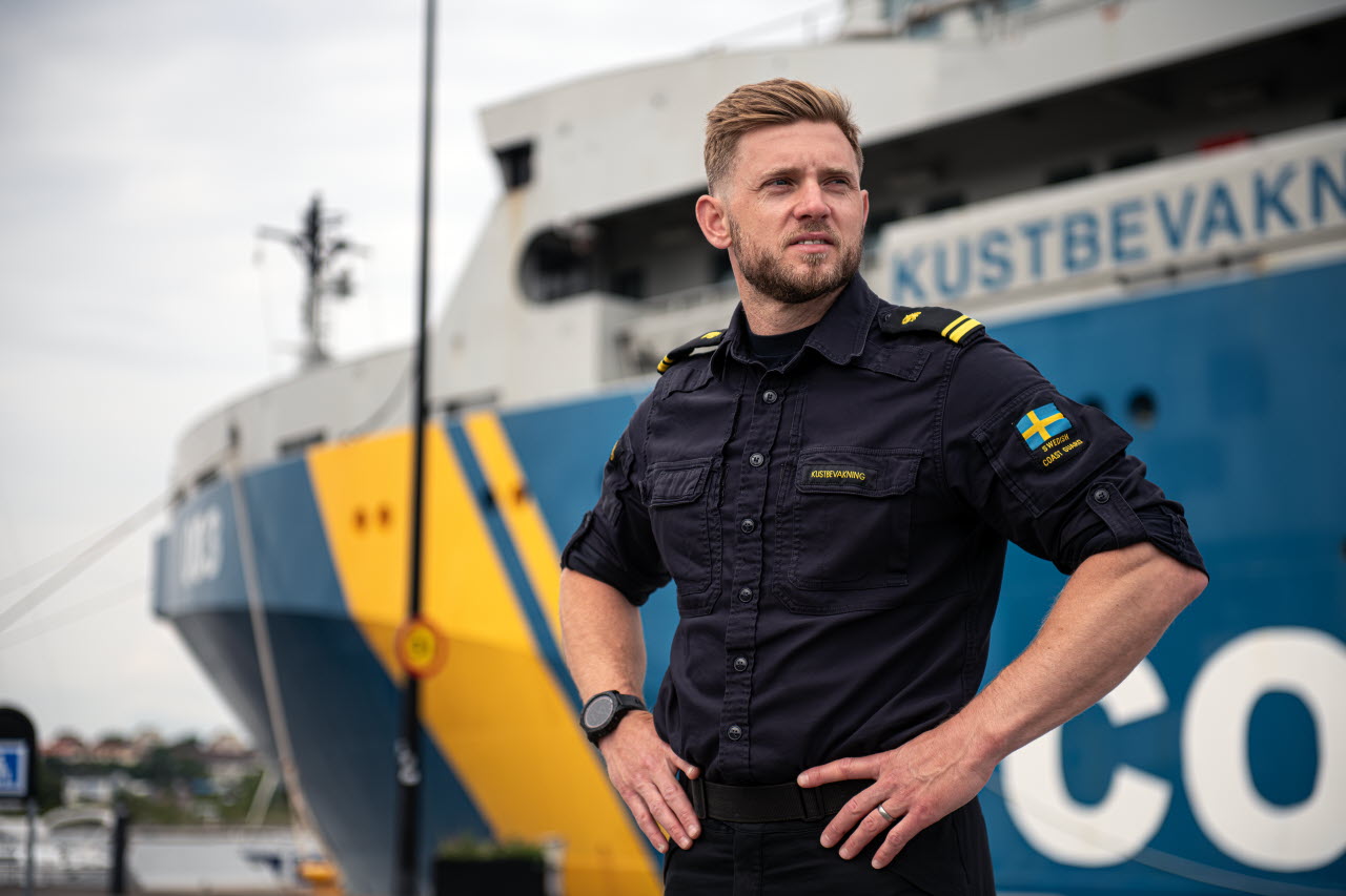 Manlig kustbevakare på kajen med KBV003 i bakgrunden. 