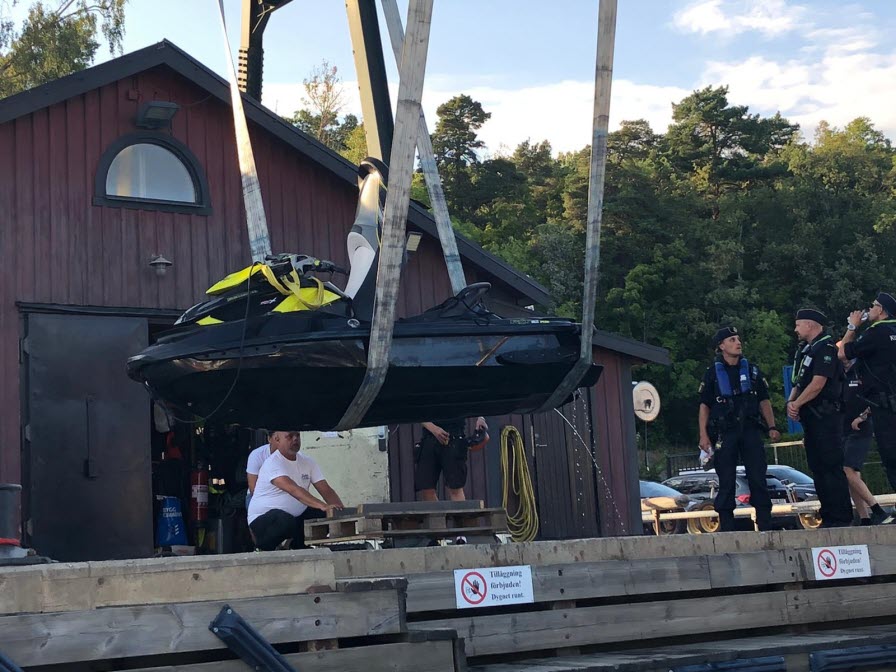 Vattenskoter hissas upp ur vattnet, polis och kustbevakare tittar på