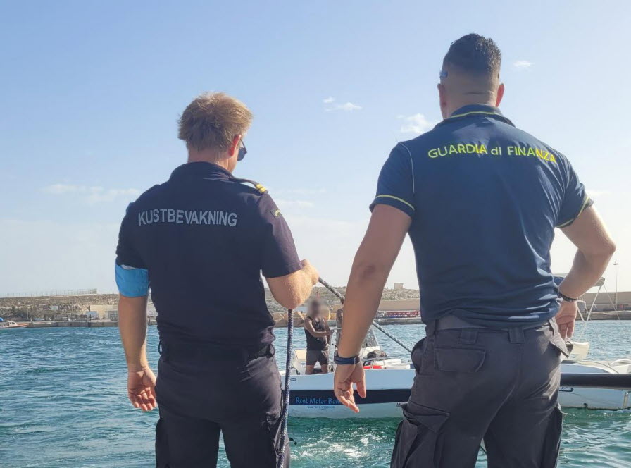 Ryggen på en svensk kustbevakare intill en anställd på italienska Guardia di Finanza.