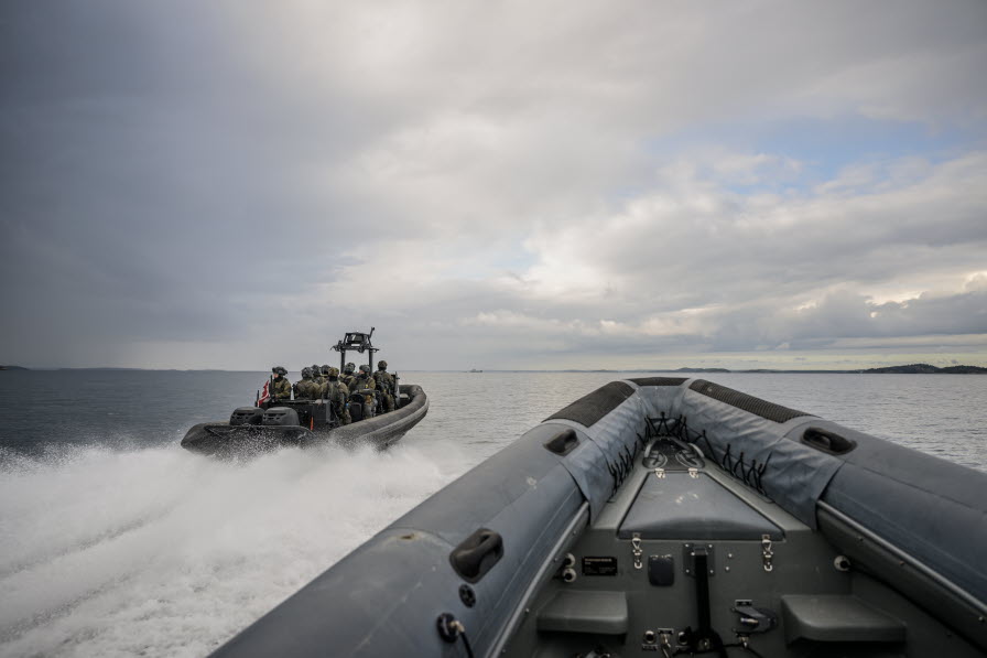 Två ribbåtar med insatsstyrkor ombord kör i hög hastighet över havet.