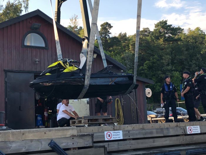 Vattenskoter hissas upp ur vattnet, polis och kustbevakare tittar på