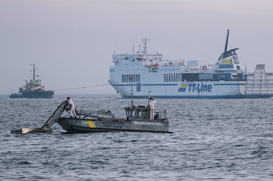Kustbevakningsbåt tar upp olja